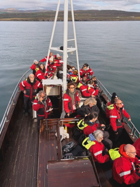 whale watching passengers enjoying solar eclipse in Iceland